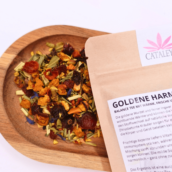 Lose Bio-Teemischung Goldene Harmonie mit Hagebuttenschalen, Kräutern und Blüten auf einem Holzschälchen neben der geöffneten Verpackung von Cataleya.