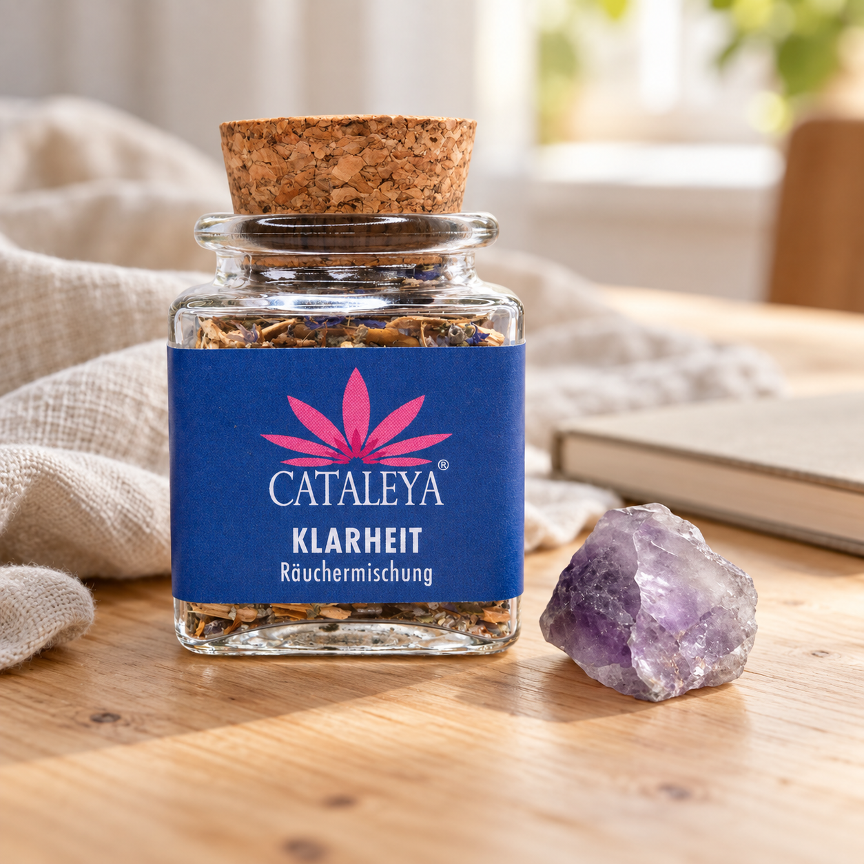 CATALEYA Klarheit-Räuchermischung im Glas neben einem Amethyst auf einem Tisch.