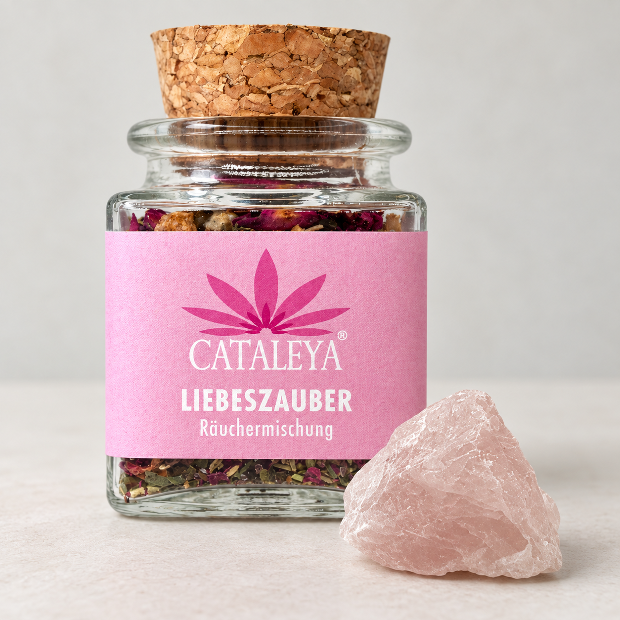 CATALEYA Liebeszauber-Räuchermischung im Glas neben einem Rosenquarz.